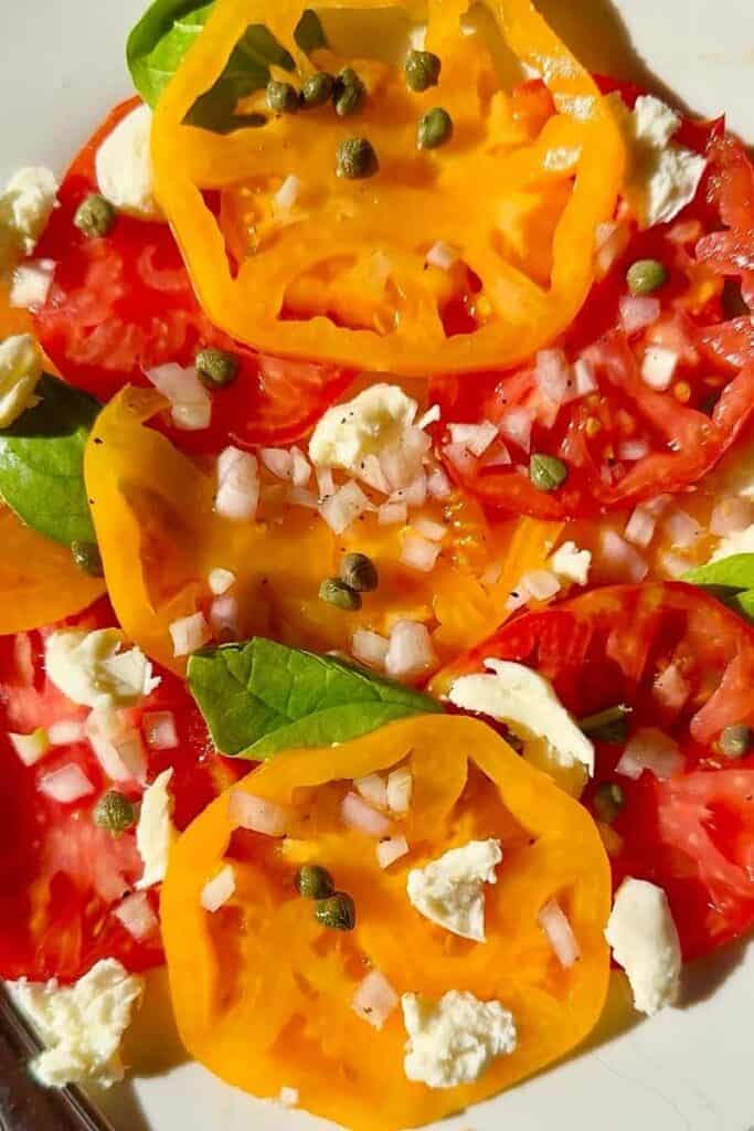Close-up of tomato carpaccio salad with olive oil and fresh basil