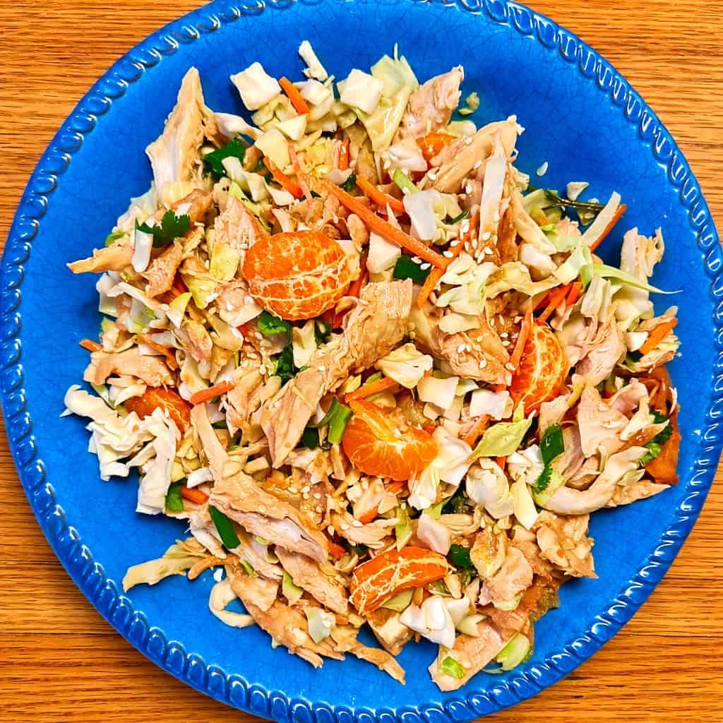 Rotisserie chicken Chinese salad with cabbage slaw, shredded chicken meat, carrots, mandarin oranges, and sesame seeds.