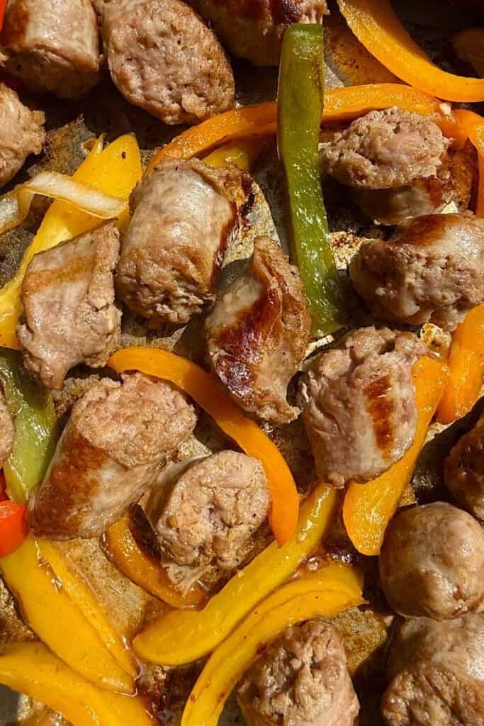 Close-up of authentic Italian sausage and peppers with sliced bell peppers and browned sausage pieces cooked in a skillet.