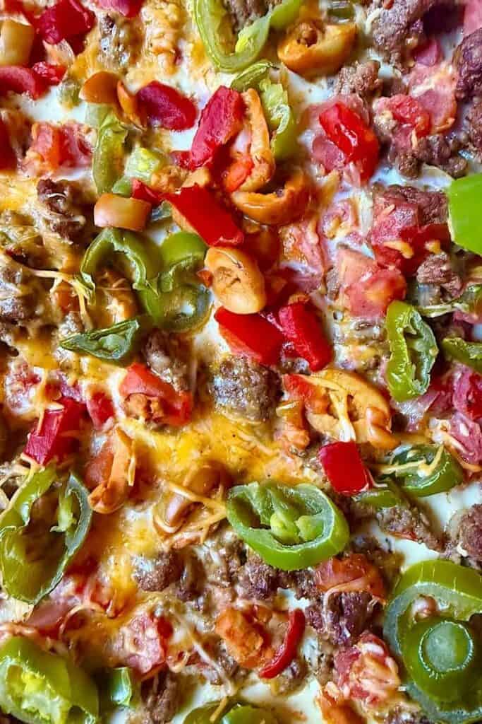 Close-up of baked taco casserole with ground beef, cheese, tomatoes, green peppers, and olives after oven baking