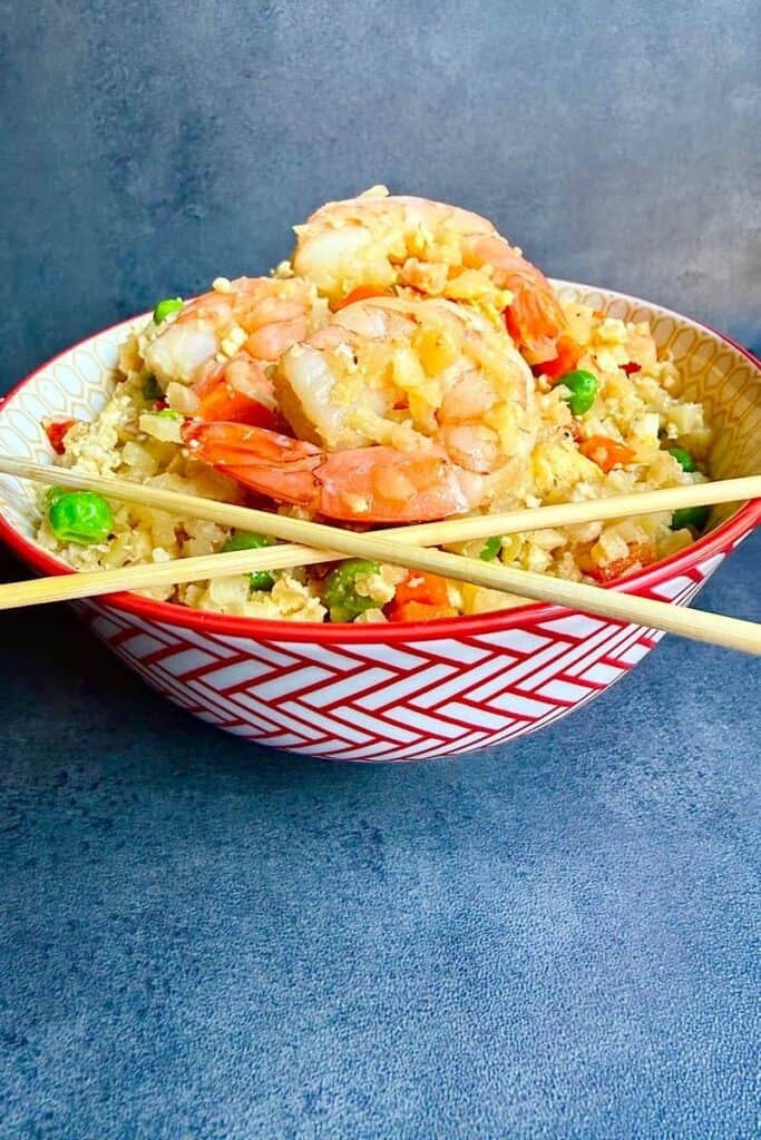 Shrimp cauliflower fried rice served in a patterned bowl with chopsticks