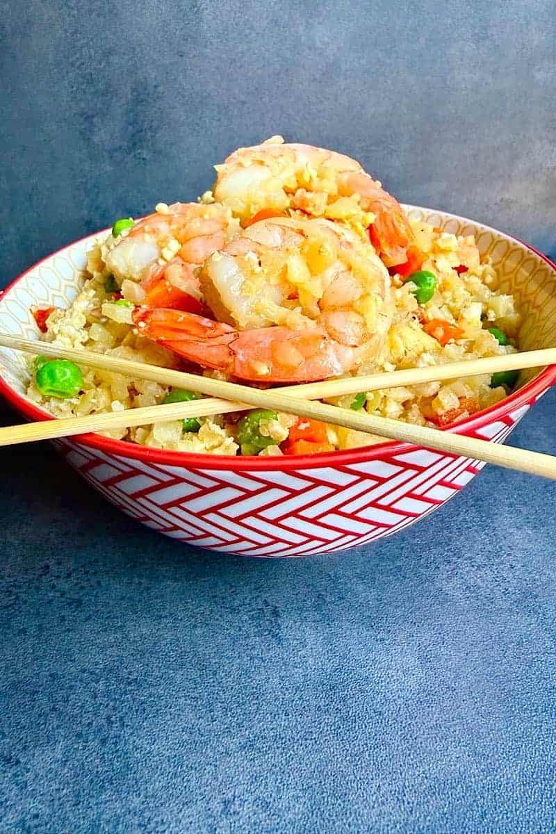 Shrimp cauliflower fried rice served in a patterned bowl with chopsticks
