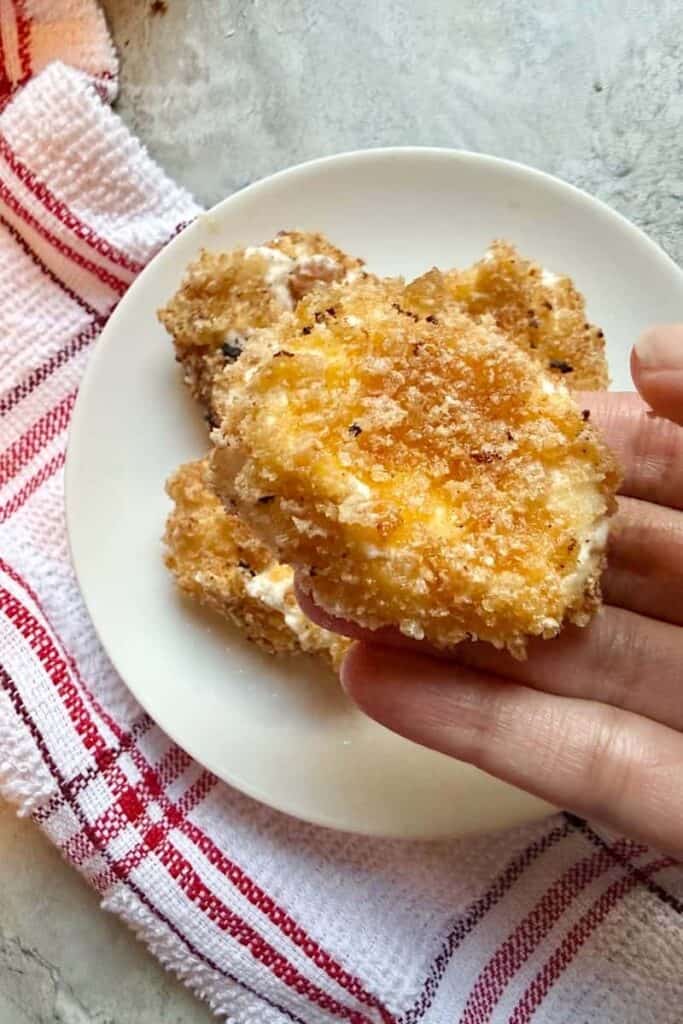Breaded goat cheese rounds coated in crushed pork rinds before frying