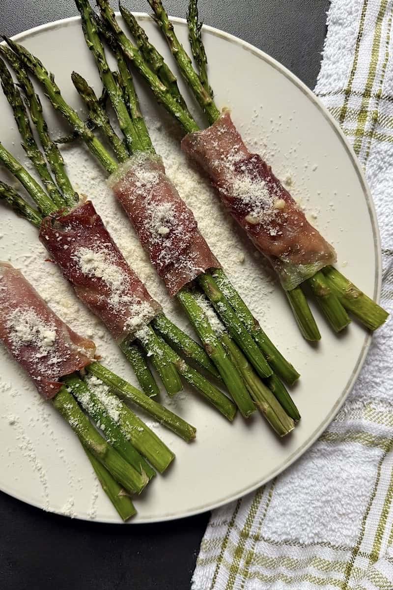 Asparagus spears wrapped in prosciutto with melted cheese inside