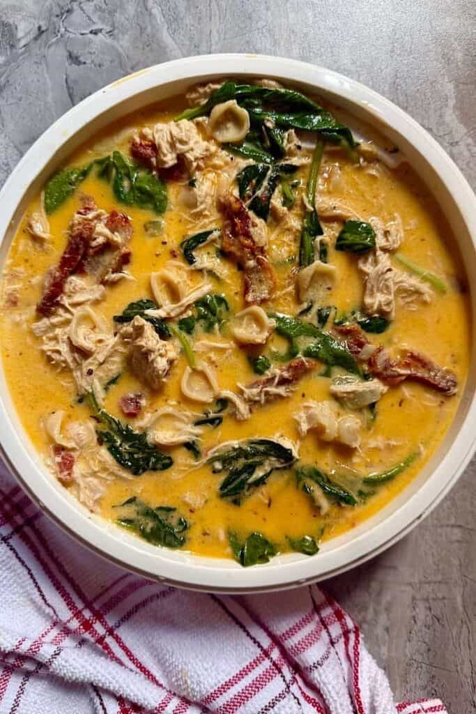 Overhead view of creamy Marry Me Soup made with rotisserie chicken, spinach, sun-dried tomatoes, and low-carb shell pasta.
